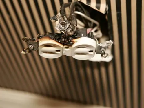 An electrical outlet, burnt and damaged